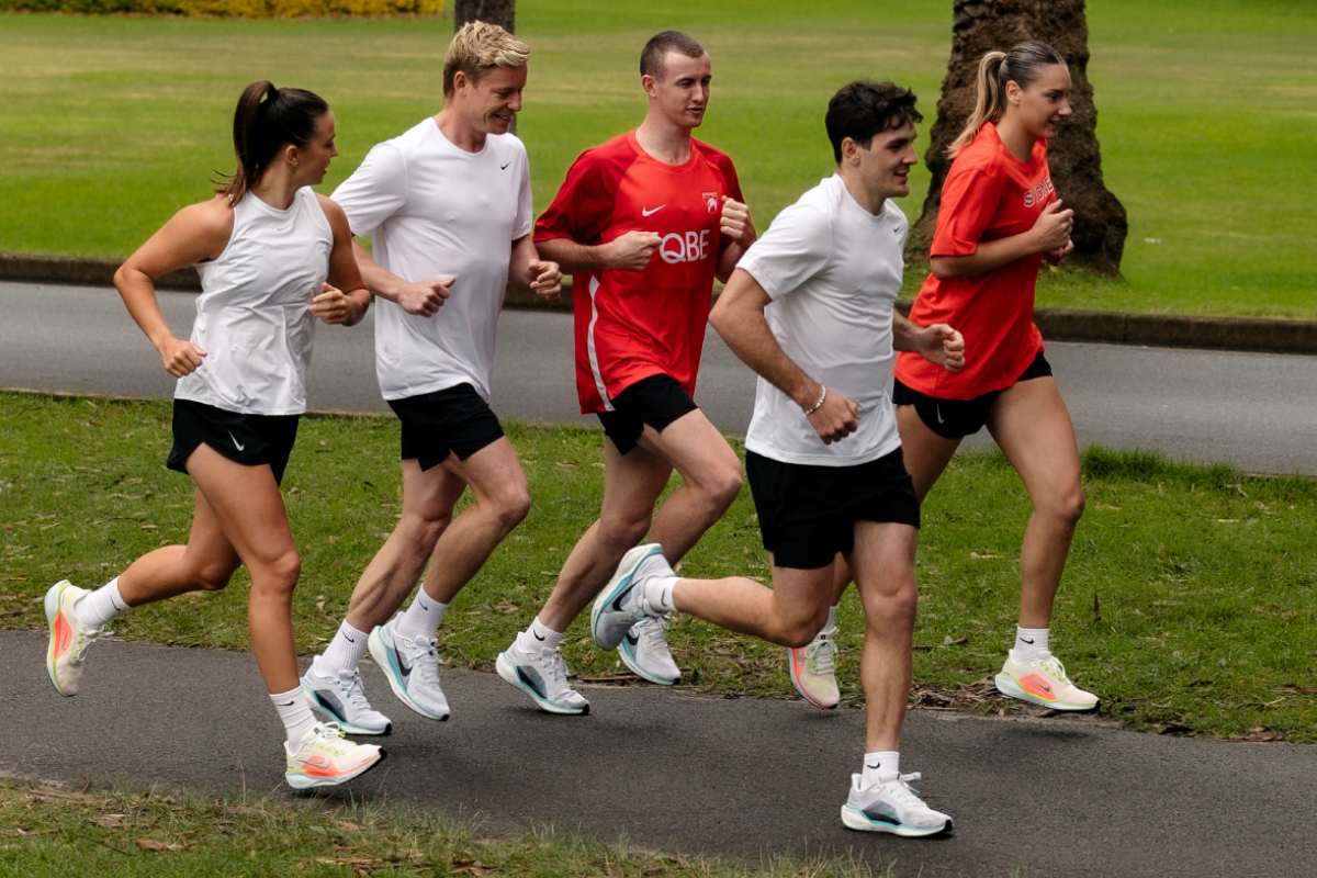 Five Sydney Swans players, three men and two women, jogging together in a park, wearing Nike Pegasus 41 running shoes